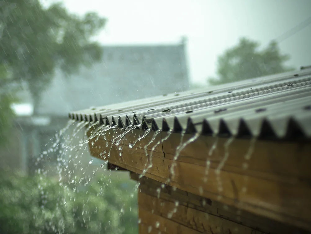 rain water pouring off a metal roof